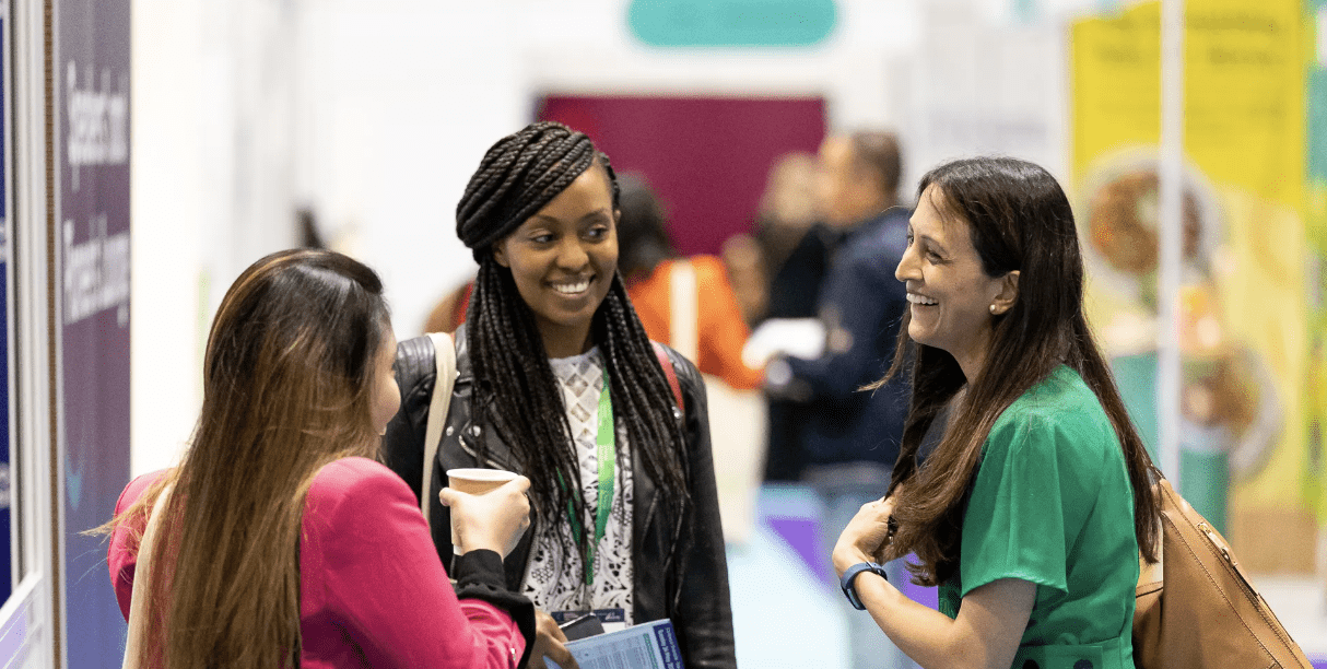 Three women are talking and laughing together at Care Show London