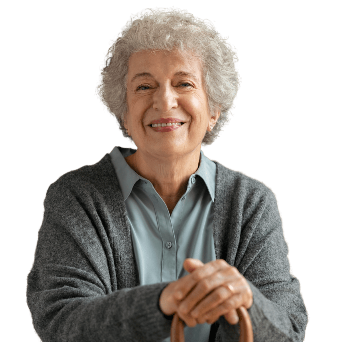 An older woman with a cane smiles for the camera